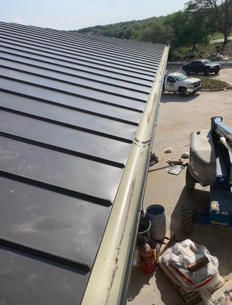 Standing seam panel and gutter detail on a metal roofing jobsite in Oak Hills